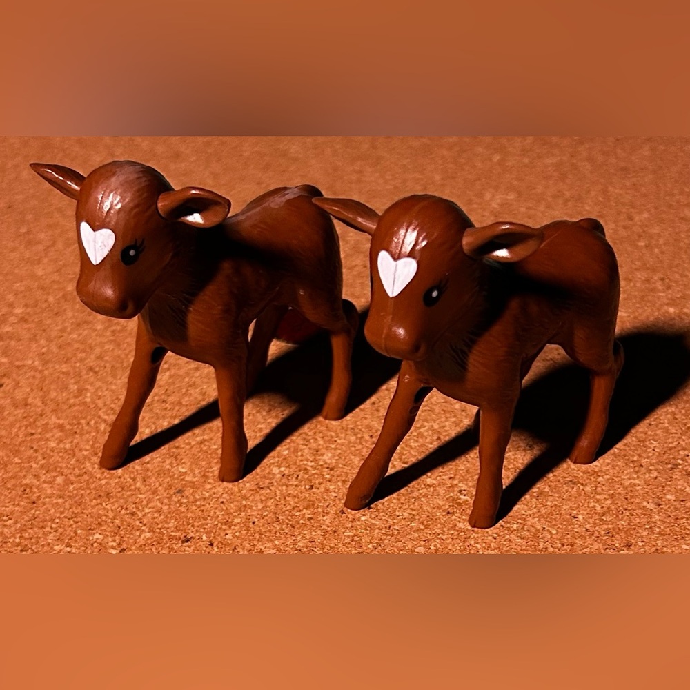 These are Mattel Barbie Sweet Orchard Farm brown calf cow figures.